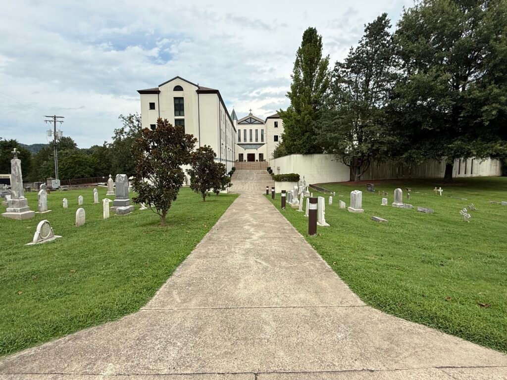 Concrete path through the cemetery leading up to retreating house and the Abbey church