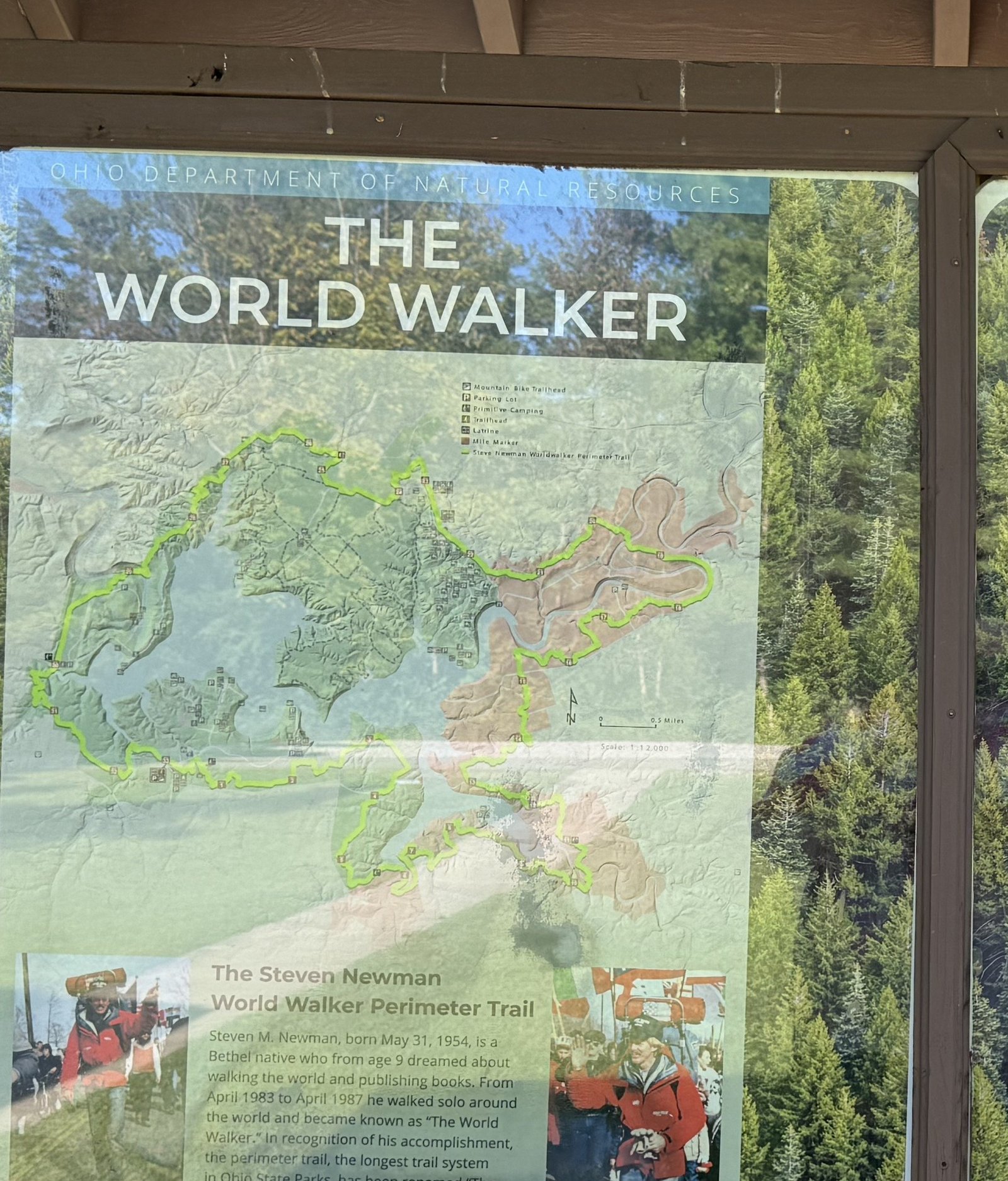 An interpretive panel headed The World Walker, showing the perimeter trail looping around the lake and a photograph of Steven Newman on the road