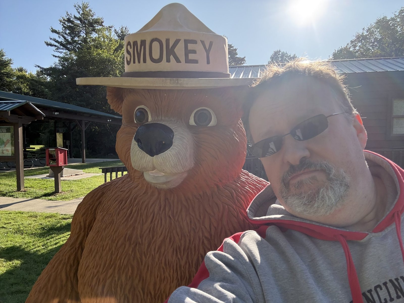 The author standing beside a life-size Smokey Bear statue outside the nature center on a bright morning