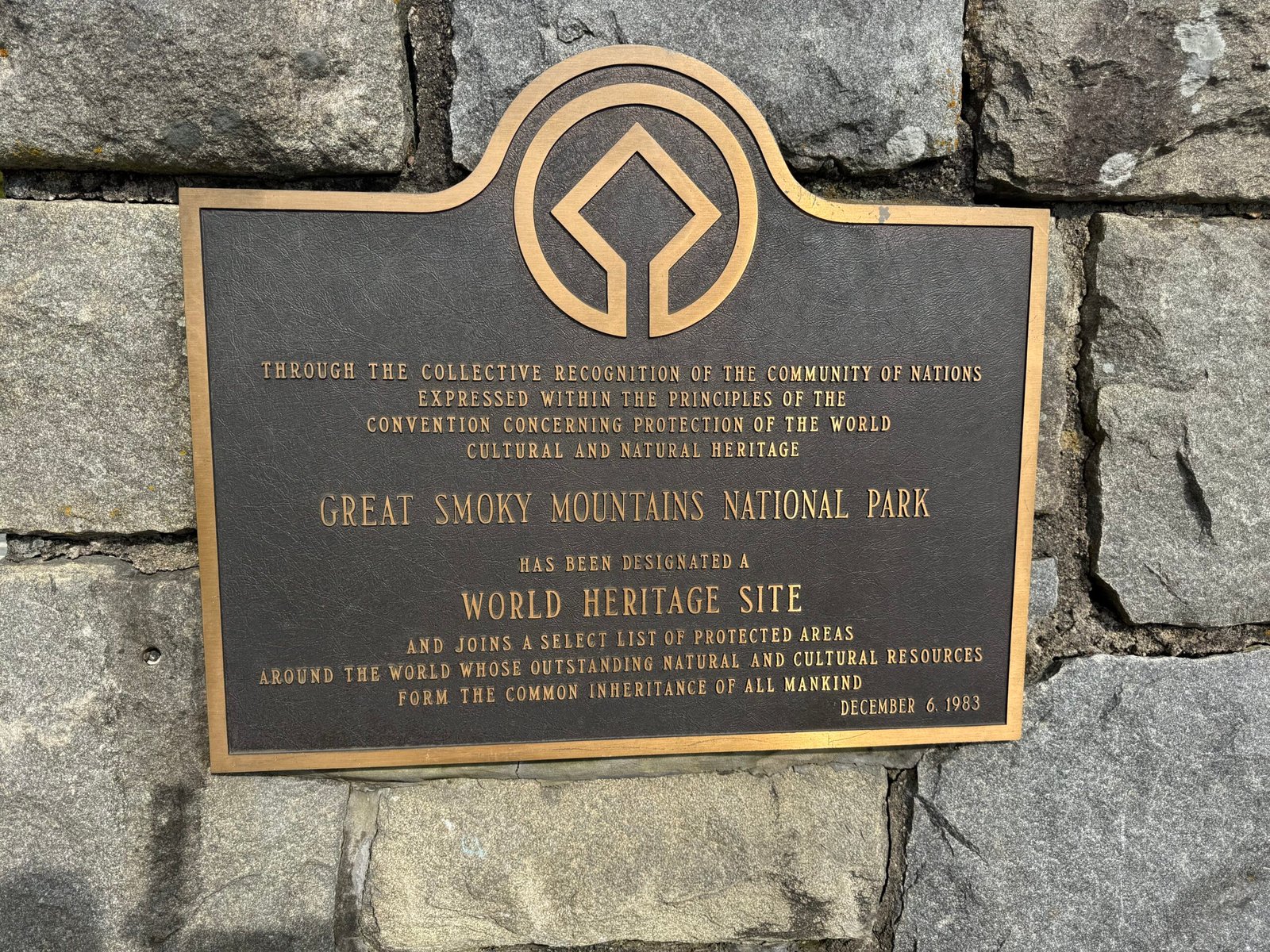 A bronze plaque set in a stone wall at Newfound Gap marking Great Smoky Mountains National Park as a World Heritage Site